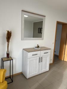 a bathroom with a white cabinet and a mirror at Sunset Apartment mit Rheinblick in Urbar in Urbar