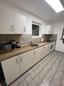 a kitchen with white cabinets and a sink at Sunset Apartment mit Rheinblick in Urbar in Urbar