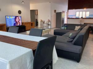 a living room with couches and a flat screen tv at L’escale petite terre in Labattoir