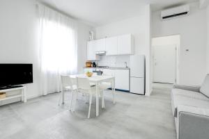 a white kitchen with a table and chairs in a living room at Casa MAC - New and Confortable - Near the Center and Station in Verona