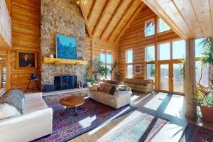 a living room with a stone fireplace in a log cabin at Lake Springs Luxury in Glenwood Springs