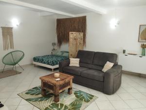 sala de estar con sofá y mesa de centro en Logement 4 à 6 personnes avec Jacuzzi en Les Trois-Îlets