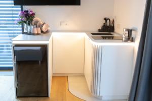 a kitchen with a white counter with a dishwasher at mariaAPPARTMENTS in Gramatneusiedl