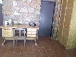 a desk with a chair and a stone wall at The Pool House @ Salbu in Centurion