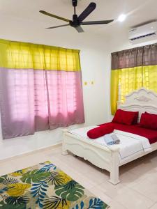 een slaapkamer met een bed met rode en gele gordijnen bij Malin's Homestay Kota Bharu in Kota Bharu