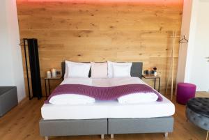 een slaapkamer met een groot bed met een houten hoofdeinde bij mariaAPPARTMENTS in Gramatneusiedl