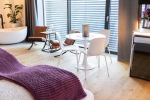 a living room with a table and chairs and a tub at mariaAPPARTMENTS in Gramatneusiedl