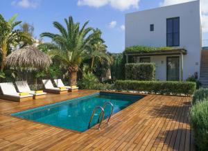 una piscina con sillas y una casa en Es Caló Luxe - Formentera Break, en Es Caló