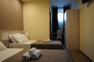Dos camas en una habitación con toallas. en B&B President's Home en Matera