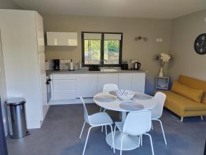 a kitchen and living room with a table and chairs at Gîte de charme in Barbazan