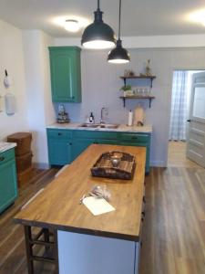 a kitchen with green cabinets and a wooden table at Cozy Getaway in Lincoln! 