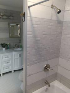 a bathroom with a shower with a toilet and a sink at Cozy Getaway in Lincoln! 
