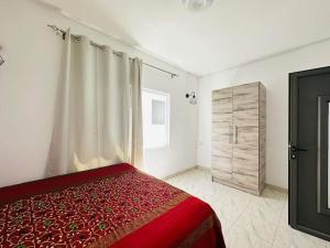 a bedroom with a red bed and a wooden cabinet at Villa Calodyne in Goodlands