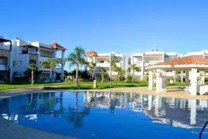 a swimming pool in front of some apartment buildings at assilah marina golf assilah in Asilah