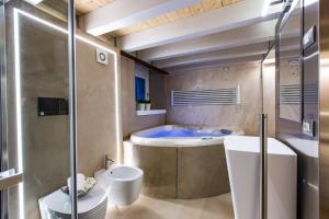 a bathroom with a tub and a toilet and a sink at Luxury Wellness Verona Spa in Verona