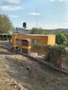 a yellow building with a fence in front of it at Casa de Alquiler 1 in Tanti