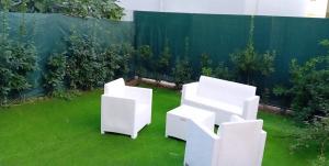 two white chairs sitting on the grass in a backyard at Villa Levante in Barletta