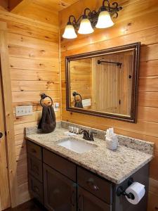 baño con lavabo y espejo grande en Pine Mountain Luxury Cabin Bordering Roosevelt Park and 7 Min to Callaway Gardens, en Pine Mountain Valley