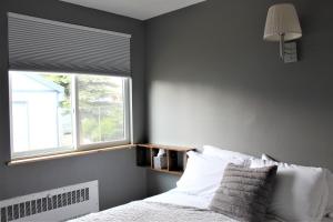 a bedroom with a bed with a window and a white bedspread at The Abbey in Leadville