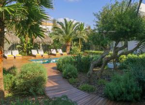 einen Garten mit Stühlen, Bäumen und einem Pool in der Unterkunft Es Caló Luxe - Formentera Break in Es Caló