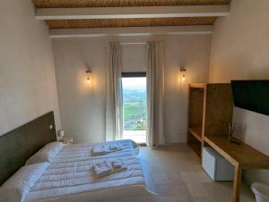 a bedroom with a large bed and a large window at Case al Borgo-Agira Centre-Home Relais in Agira