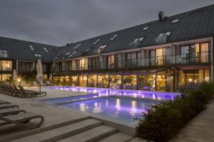 a hotel with a swimming pool in front of a building at Saltic Resort & Spa Łeba in Łeba