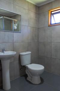 a bathroom with a toilet and a sink at Cabaña Alto Arrayán in Pucón +16 photos