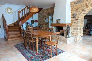 uma sala de jantar com uma mesa de madeira e cadeiras em Rare pearl with garden facing the sea em Saint-Coulomb