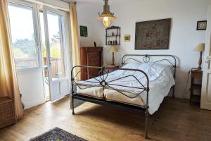 a bedroom with a bed and a large window at Rare pearl with garden facing the sea in Saint-Coulomb