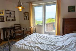 a bedroom with a bed in front of a window at Rare pearl with garden facing the sea in Saint-Coulomb