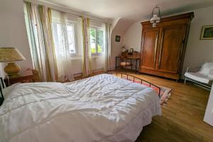 a bedroom with a large white bed and a window at Rare pearl with garden facing the sea in Saint-Coulomb +14 photos