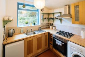 a kitchen with a sink and a stove top oven at Peaceful 2BD Home - 18 mins to Bath City Centre! in Bath