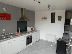 a kitchen with white cabinets and a sink at A Vol d'oiseau in Méreau