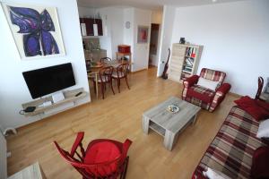 sala de estar con TV, sillas y mesa en Thomas apartment 028, en Liubliana