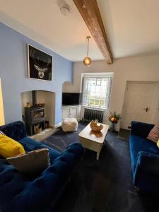 a living room with a blue couch and a table at Castle Yard Cottage in Knaresborough