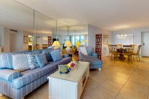 a living room with a blue couch and a table at Crystal Waves in Marco Island