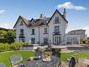 uma grande casa branca com uma mesa e cadeiras em 3 bed in Teignmouth 91466 em Teignmouth