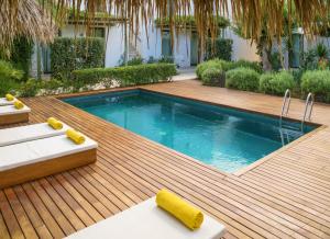 einen Pool auf einer Holzterrasse mit einem Pool in der Unterkunft Es Caló Luxe - Formentera Break in Es Caló