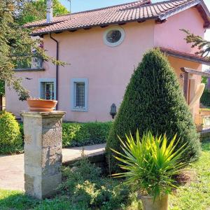 uma casa com um grande arbusto em frente em Casa di Campagna em Ronciglione