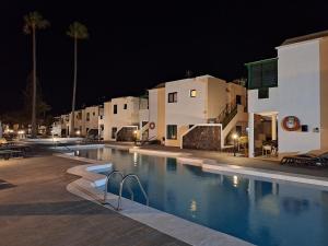a swimming pool in front of some buildings at night at Casa Limoncello in Puerto del Carmen