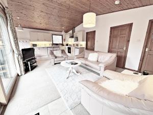 ein Wohnzimmer mit einem Sofa und einem Tisch in der Unterkunft Fisher chalet in Crianlarich