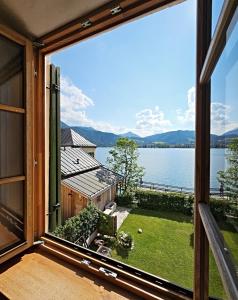 a large window with a view of a lake at Ferienhaus Steinbacher direkt am Tegernsee in Tegernsee