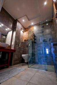 a bathroom with a glass shower and a toilet at Przytulnie z The GG Apartments in Poznań