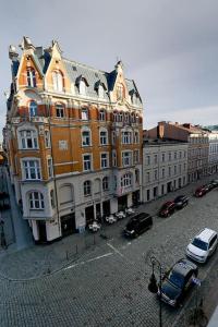 un grande edificio con macchine parcheggiate di fronte di Przytulnie z The GG Apartments a Poznań