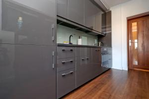 a kitchen with stainless steel appliances and a wooden floor at Przytulnie z The GG Apartments in Poznań
