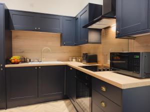 a kitchen with navy blue cabinets and a microwave at Station House Haworth in Haworth