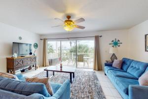 a living room with blue couches and a tv at Captain's Cove 304 in Clearwater Beach