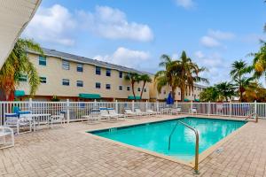 a swimming pool in front of a building with a resort at Captain's Cove 304 in Clearwater Beach