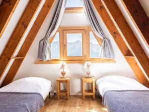 two beds in a room with a window at Chalet Huez, 5 pièces, 8 personnes - FR-1-645-14 in LʼHuez