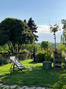een stoel en een tafel in de tuin bij La Villa Lauvray in Vétheuil